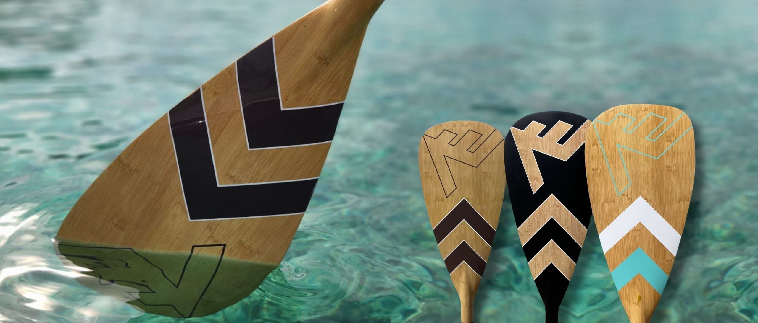 Wooden paddles with tribal designs on a water background. VAMO Adventure Series SUP Paddles